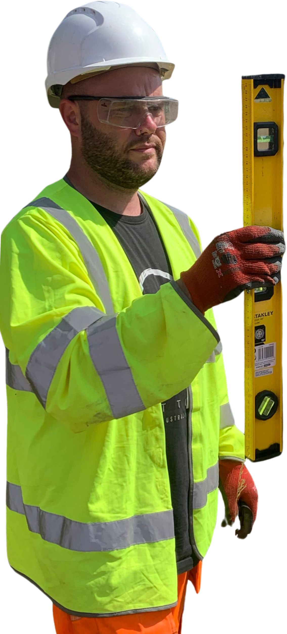 A white male in a yellow high vis jacket, orange high vis trousers and a white hard hat, wearing red electrical gloves is holding a spirit level vertically in his right hand. He looks deep in concentration and experienced.