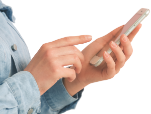 A white person in a denim jacket typing on their mobile phone
